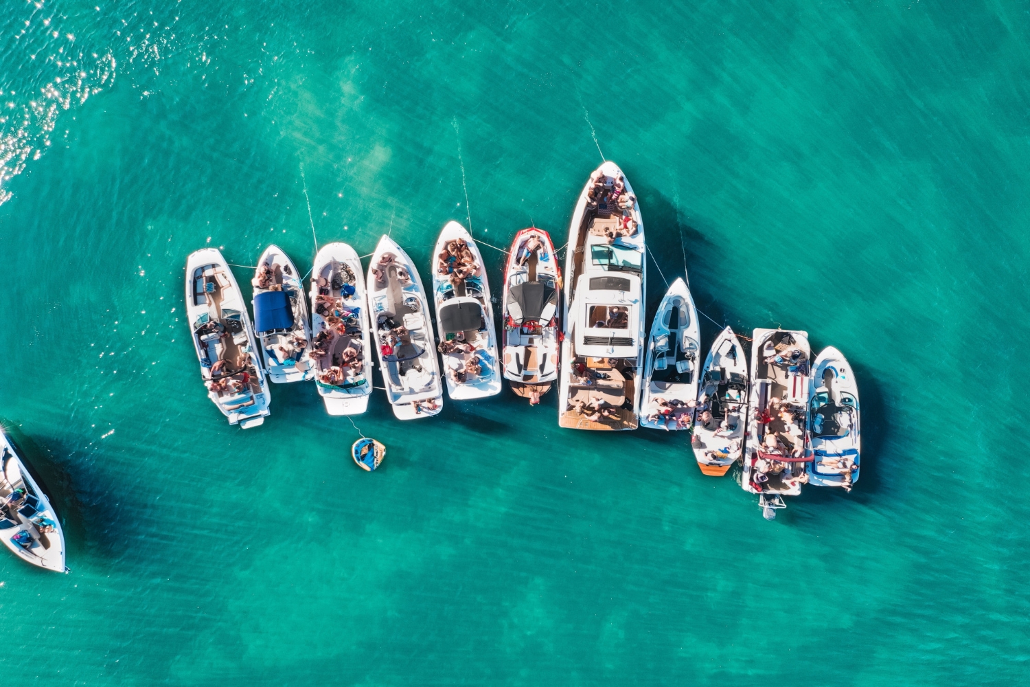 Aerial view of a raft-up of tour boats on turquoise water in Curaçao